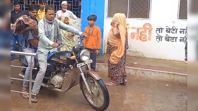 शर्मनाक: भारी बारिश में नाबालिग बेटे का शव मोटरसाइकिल से घर ले गए गए परिजन, अस्पताल से नहीं मिली एंबुलेंस