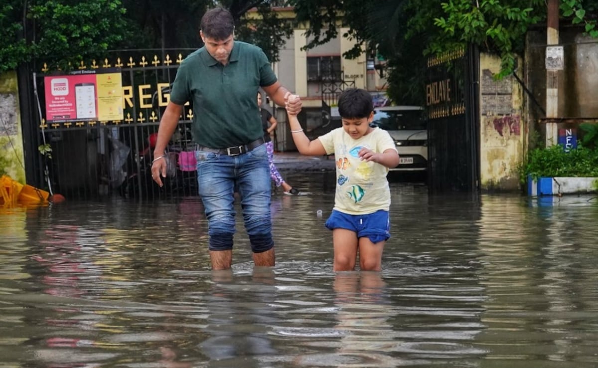 A father and son cross a waterlogged road in Kolkata A father and son cross a waterlogged road in Kolkata