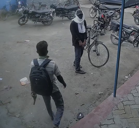 दुकान के बाहर हाथ में हथियार लिए खड़े दो बदमाश. दुकान के बाहर हाथ में हथियार लिए खड़े दो बदमाश.