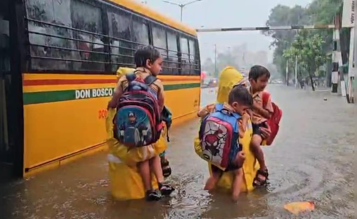 Cops can be seen rescuing students from school buses amid the heavy downpour. Cops can be seen rescuing students from school buses amid the heavy downpour.