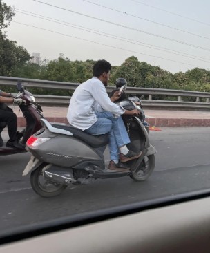 बिना हेलमेट, पैर क्रॉस करके, हाथ में फोन लिए स्कूटी चला रहा था शख्स, ट्रैफिक नियमों की उड़ाई धज्जियां