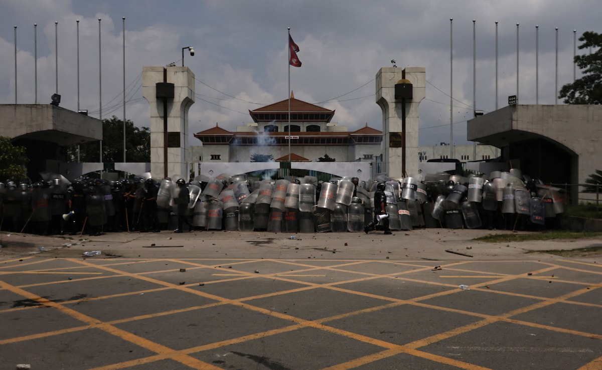 Police officers in riot gear guard the entrance of the Parliament during a protest against corruption and the governments decision to block several social media platforms.