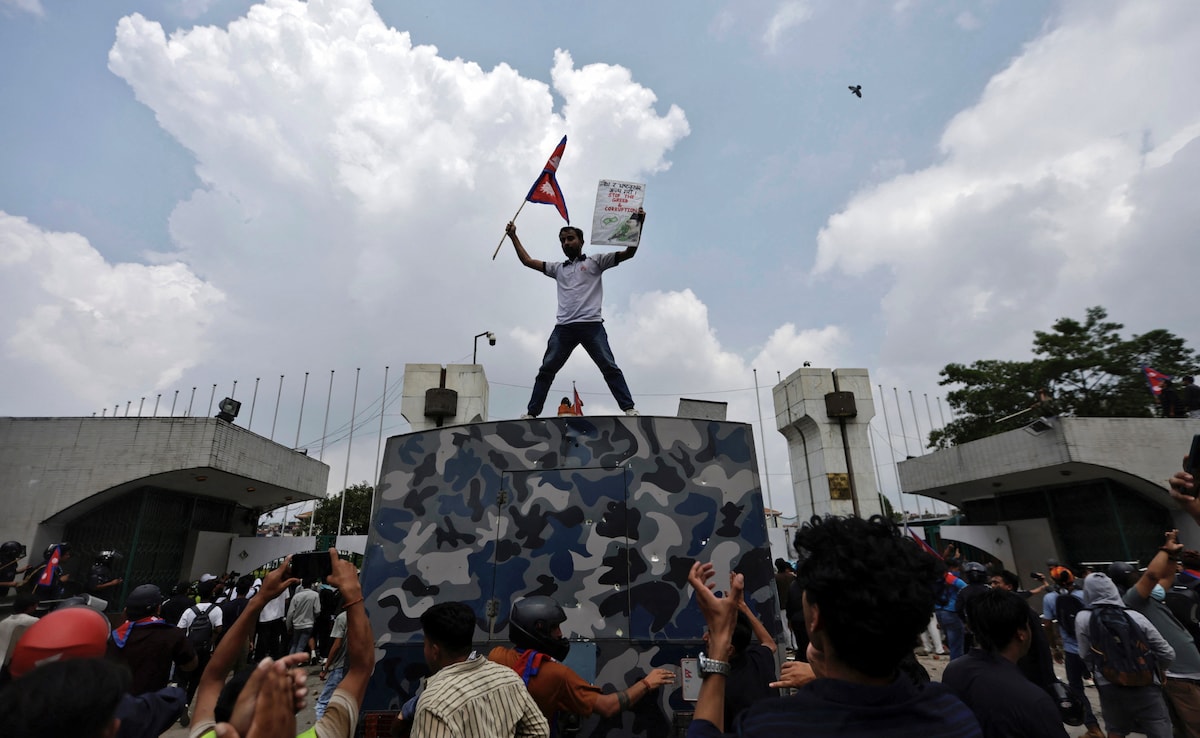 A demonstrator waves a flag as he stands atop a vehicle near the entrance of the Parliament during a protest against corruption and governments decision to block several social media platforms.