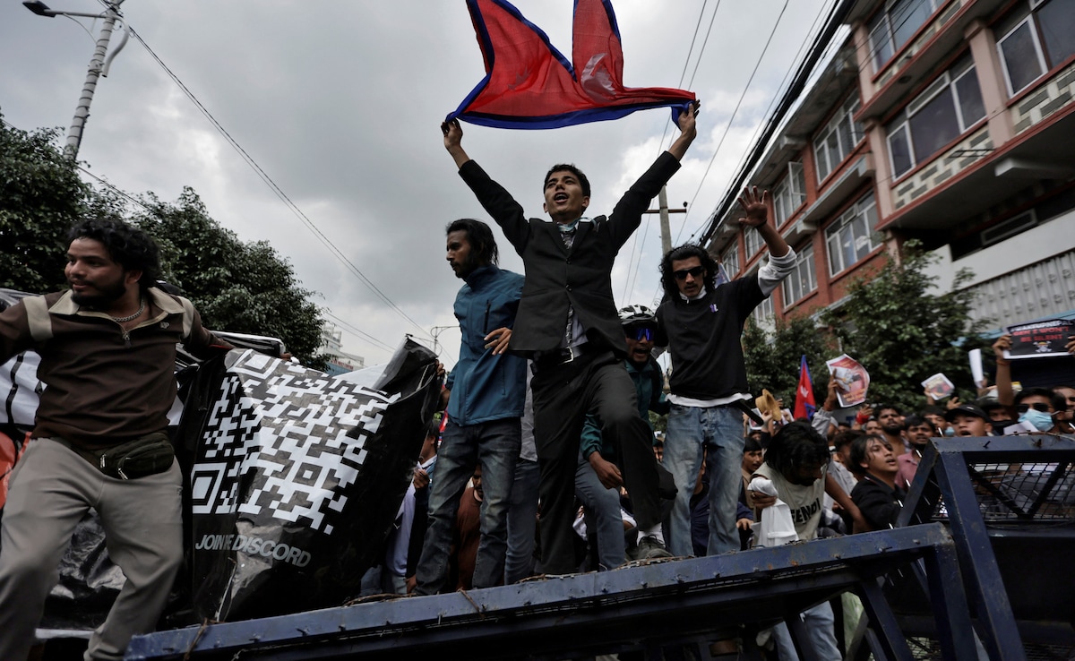 Demonstrators shout slogans as they stand on a barricade during a protest against corruption and the governments decision to block several social media platforms.