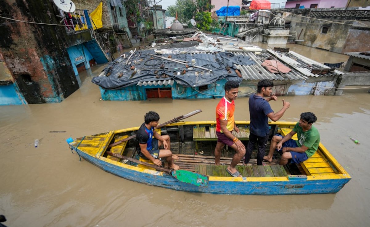 People use a boat to move through a flooded area as the water level of the Yamuna river continues to rise (PTI) People use a boat to move through a flooded area as the water level of the Yamuna river continues to rise (PTI)