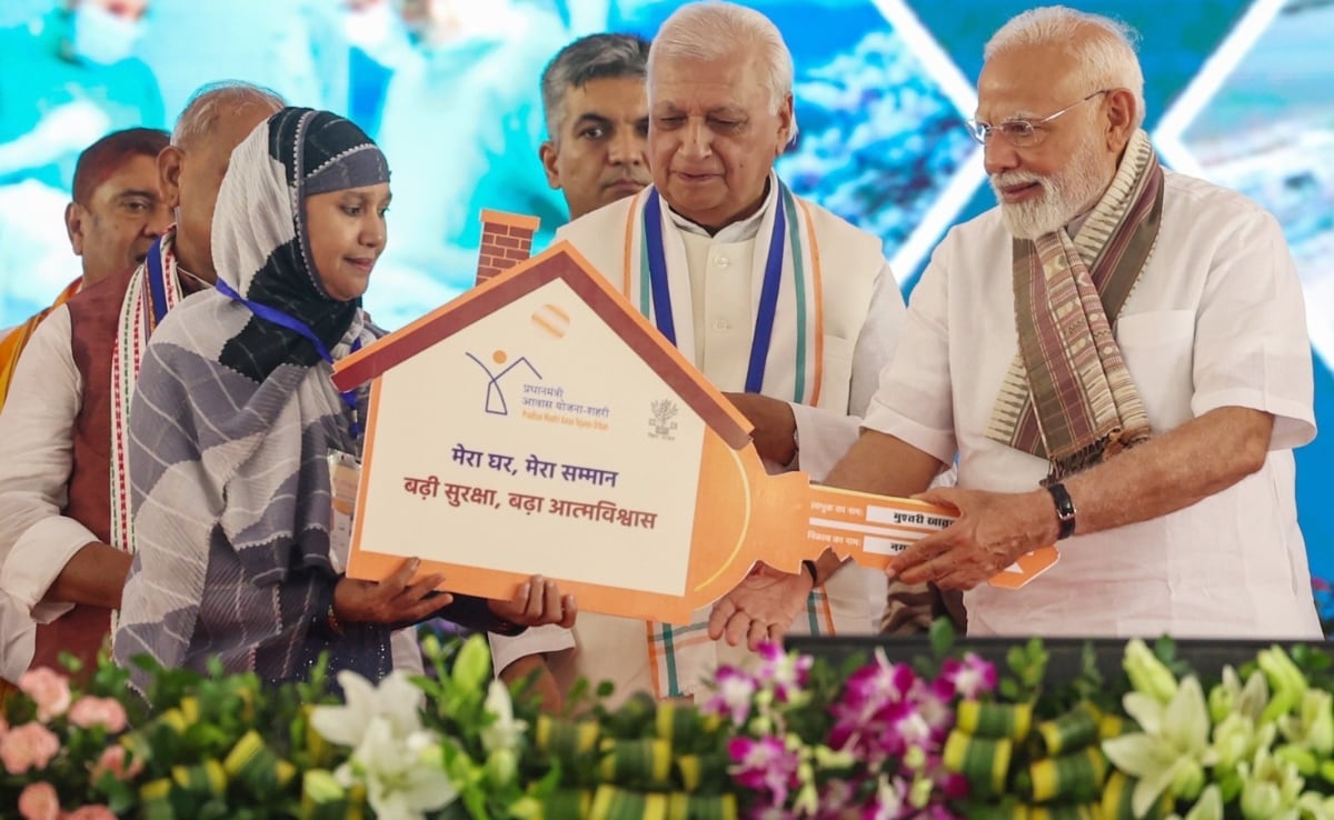 पीएम आवास योजना की एक लाभार्थी को घर की चाबी देते प्रधानमंत्री नरेंद्र मोदी. पीएम आवास योजना की एक लाभार्थी को घर की चाबी देते प्रधानमंत्री नरेंद्र मोदी.
