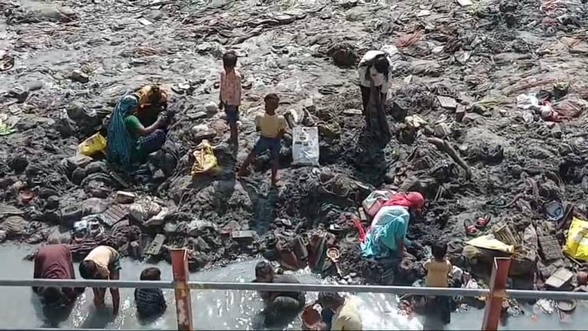 कीचड़ में कीमती चीजों की तलाश में लगे लोग. कीचड़ में कीमती चीजों की तलाश में लगे लोग.