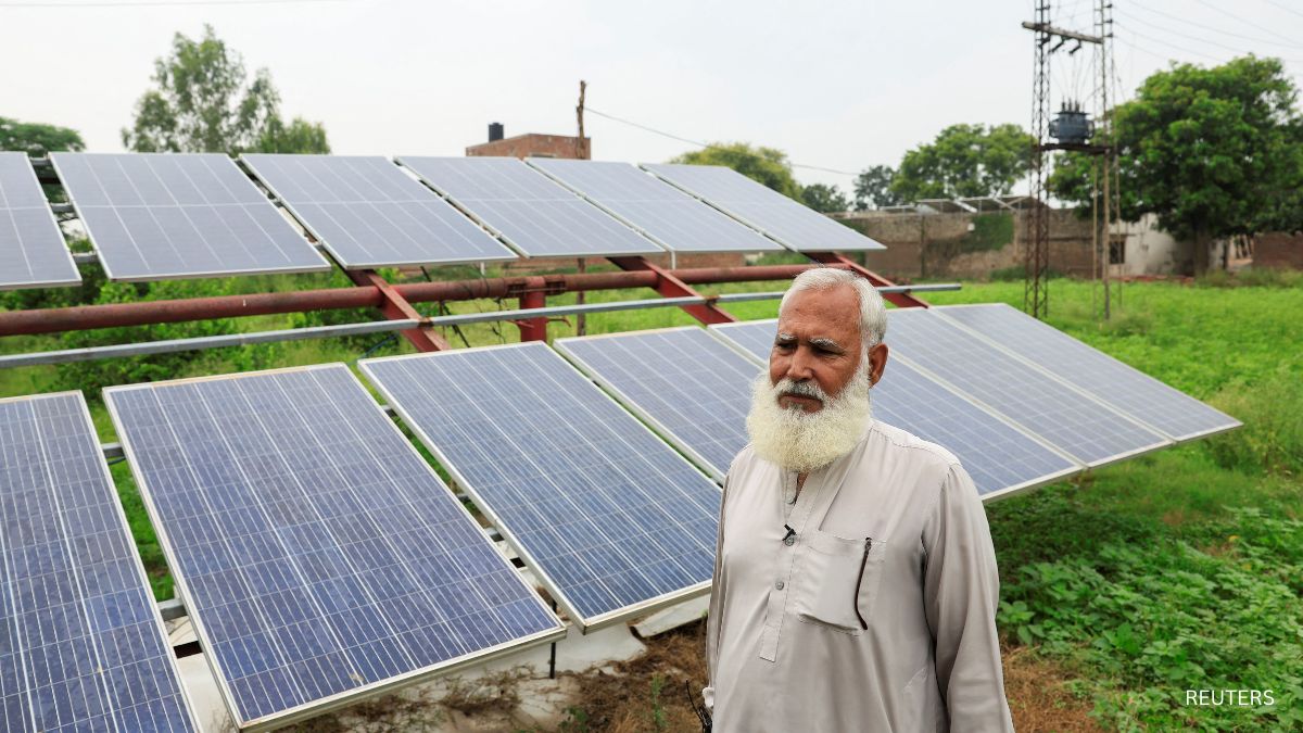 A farmer stands beside his solar panels, installed to run a tube well, in Muridke A farmer stands beside his solar panels, installed to run a tube well, in Muridke