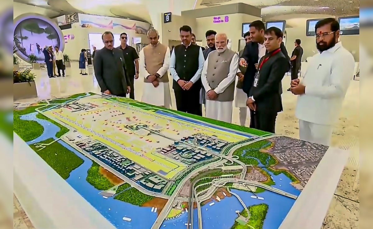 नवी मुंबई अंतर्राष्ट्रीय हवाई अड्डे (NMIA) के पहले चरण के उद्घाटन के दौरान प्रधानमंत्री नरेंद्र मोदी, महाराष्ट्र के राज्यपाल आचार्य देवव्रत, केंद्रीय नागरिक उड्डयन मंत्री राम मोहन नायडू किंजरपु, महाराष्ट्र के मुख्यमंत्री देवेंद्र फडणवीस, उप मुख्यमंत्री अजीत पवार और एकनाथ शिंदे को एयरपोर्ट का प्लान दिखाते अदाणी ग्रुप के निदेशक (एयरपोर्ट्स) जीत अदाणी. नवी मुंबई अंतर्राष्ट्रीय हवाई अड्डे (NMIA) के पहले चरण के उद्घाटन के दौरान प्रधानमंत्री नरेंद्र मोदी, महाराष्ट्र के राज्यपाल आचार्य देवव्रत, केंद्रीय नागरिक उड्डयन मंत्री राम मोहन नायडू किंजरपु, महाराष्ट्र के मुख्यमंत्री देवेंद्र फडणवीस, उप मुख्यमंत्री अजीत पवार और एकनाथ शिंदे को एयरपोर्ट का प्लान दिखाते अदाणी ग्रुप के निदेशक (एयरपोर्ट्स) जीत अदाणी.