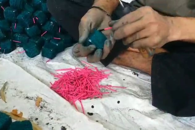 बम में सुतली डालते हुए कारीगर बम में सुतली डालते हुए कारीगर