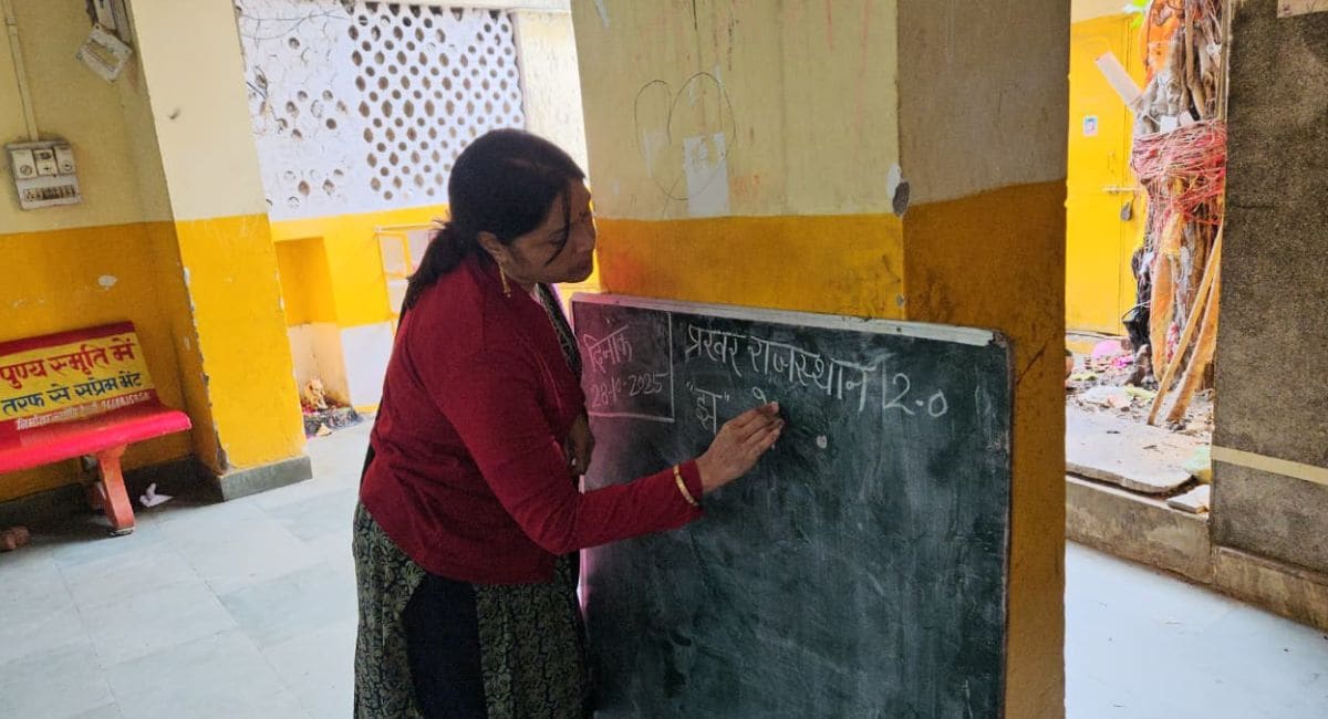 ब्लैकबोर्ड पर बच्चों को पढ़ाती शिक्षिका.  ब्लैकबोर्ड पर बच्चों को पढ़ाती शिक्षिका.