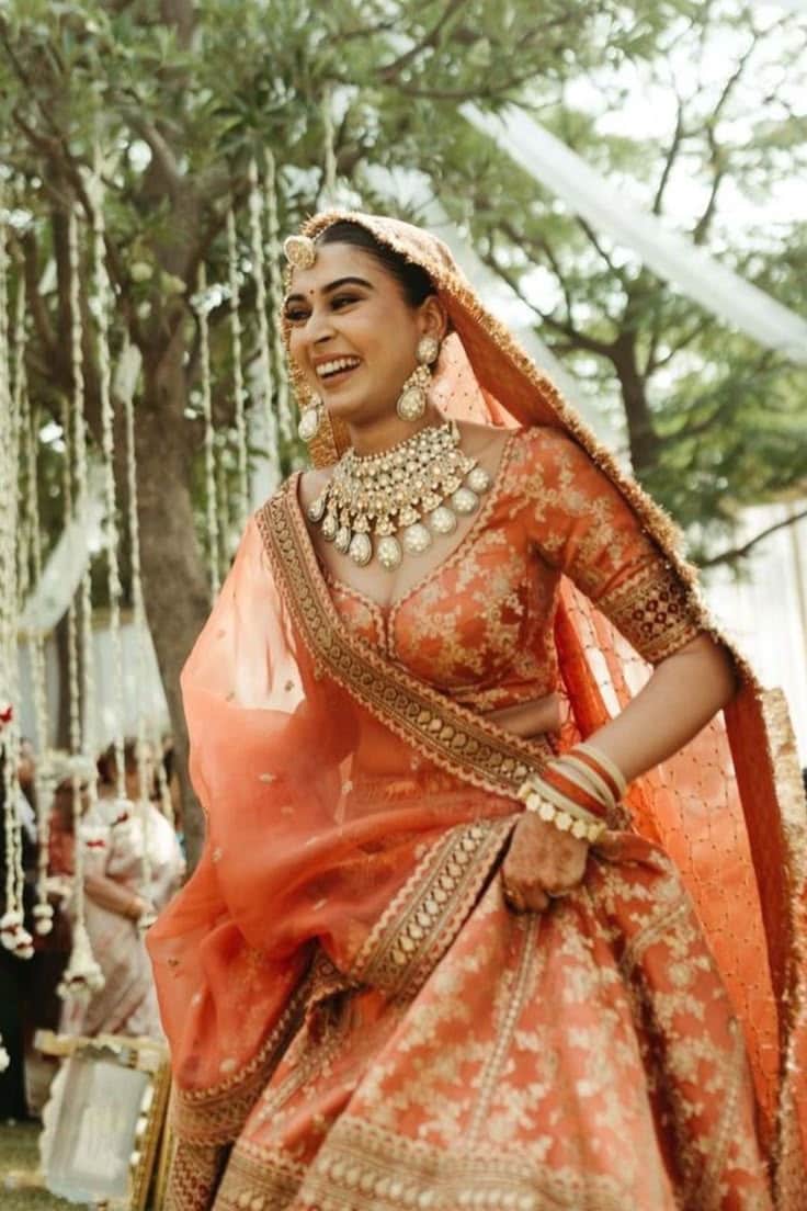 A bride in orange owns the spotlight with warmth and flair. A bride in orange owns the spotlight with warmth and flair.