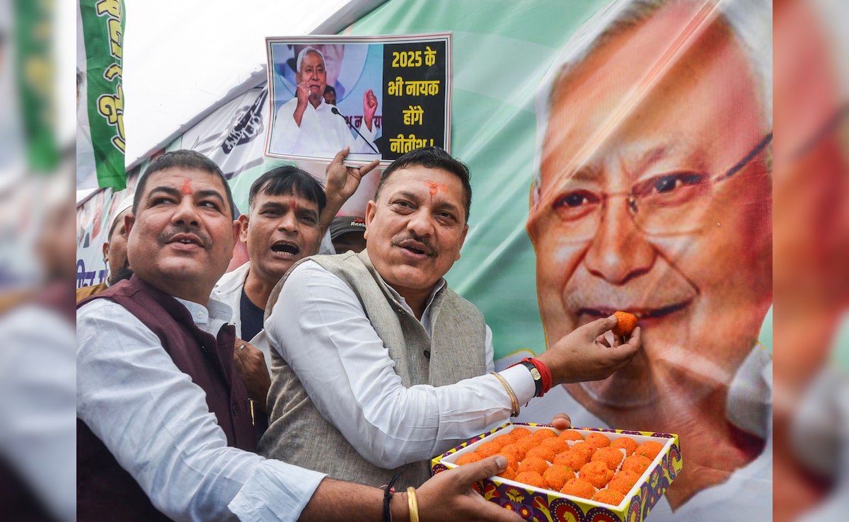 JDU members celebrate and distribute sweets in Patna as NDA heads for a big win. PTI