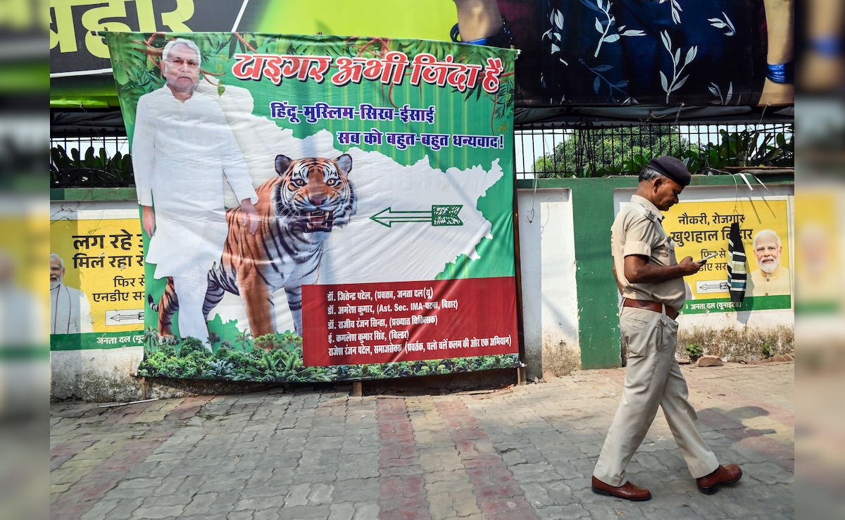 Supporters put up a poster of Bihar Chief Minister Nitish Kumar outside the party headquarters in Patna. ANI