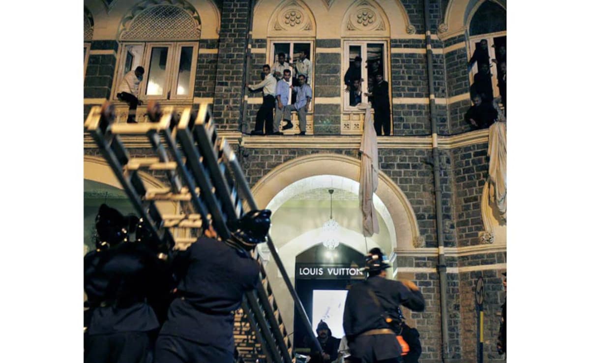 Employees and guests of the Taj Mahal hotel being rescued by firefighters after fire engulfed the top floor of the hotel.