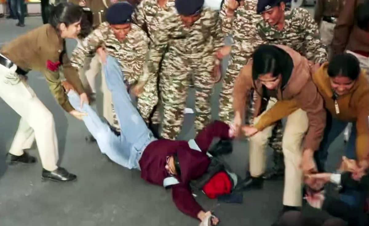 Police personnel detain people who stage a protest against rising air pollution