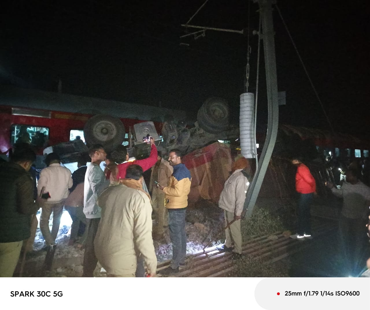 ट्रैक पर गिरे ट्रक के पास जुटे लोग. ट्रैक पर गिरे ट्रक के पास जुटे लोग.