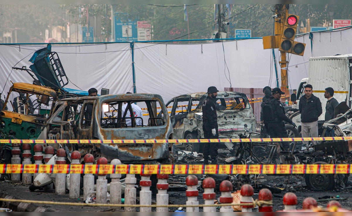 Charred remains of vehicles at a cordoned off area following a blast that occurred near Red Fort Metro on Monday. PTI