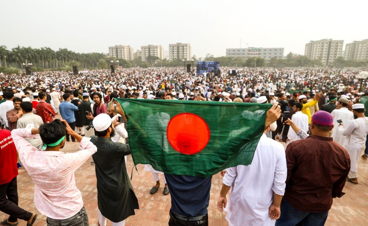A mourner holds Bangladeshs national flag during the Sharif Osman Hadis funeral. (Credit: AFP)