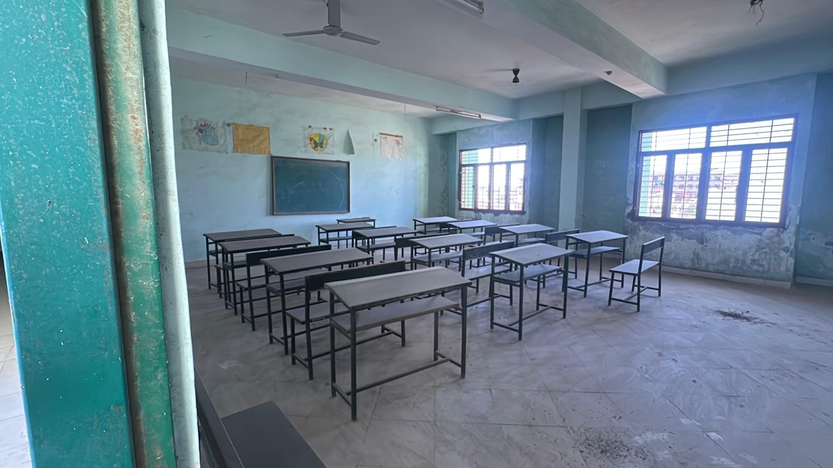 Classrooms lie deserted, and broken chairs are scattered across rooms.