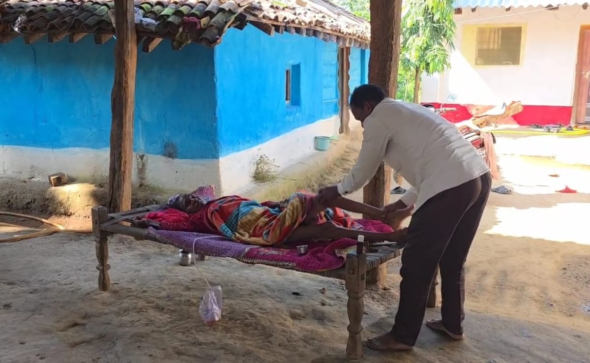 अपने घर पर पत्नी कपुरा मरकाम की देखभाल करते समलू मरकाम.