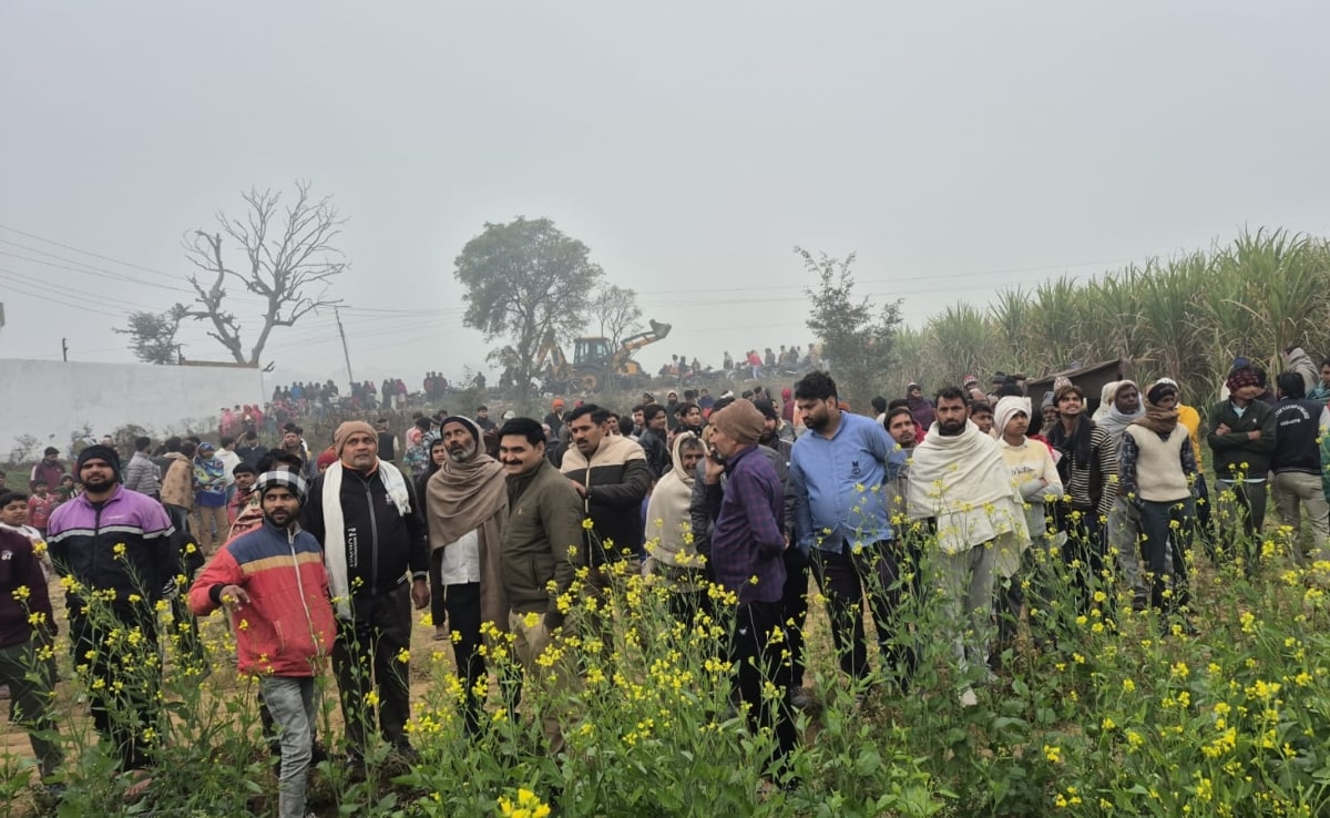 बिजली के टॉवर पर चढ़ी युवती को नीचे उतर आने के लिए अपील करते ग्रामीण.