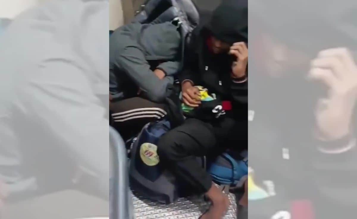 Athletes seen resting on the luggage with their heads down.