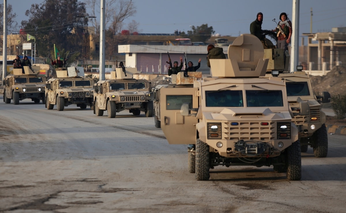 उत्तरी सीरिया के एक इलाके में समझौते के बाद विजय चिन्ह बनाते एसडीएफ के लड़ाके.