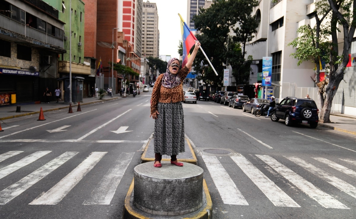 अमेरिकी हमले के खिलाफ राजधानी कराकास के एक चौराहे पर प्रदर्शन करती वेनेजुएला की एक महिला.