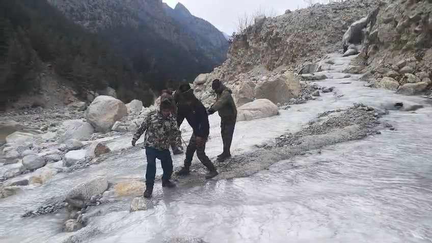 जम चुकी नदी पर सावधानी से गुजरते जवान.