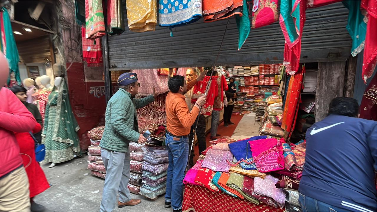 प्रदर्शनकारियों की अपील के बाद दुकानों के शटर गिराते दुकानदार.