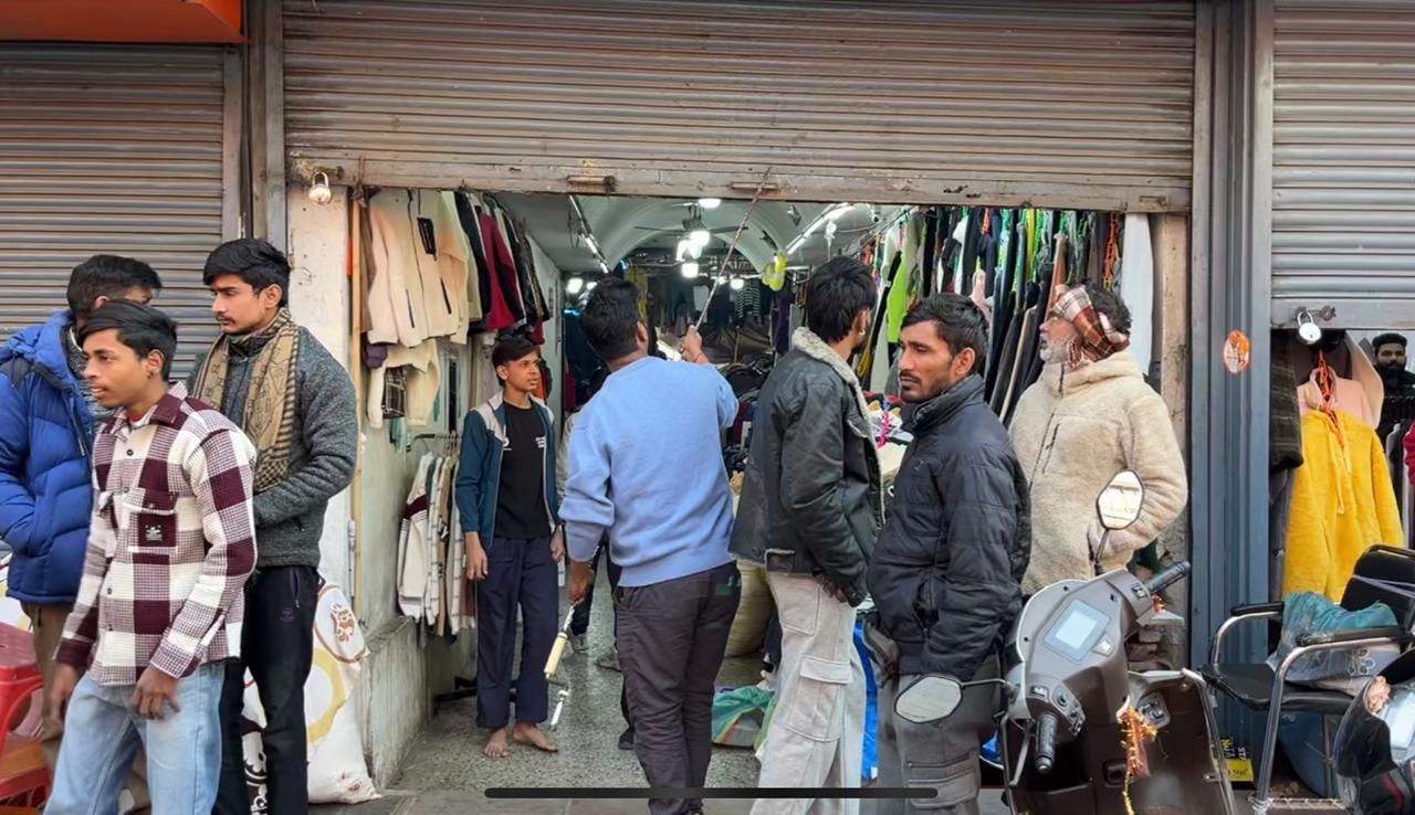 दुकान का शटर गिराते दुकानदार.