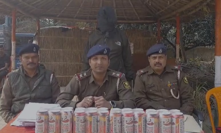 जब्त बीयर केन और शराब तस्कर के साथ पुलिस टीम.