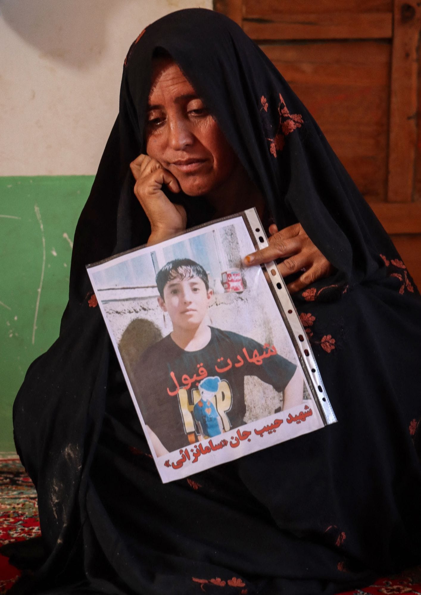 मां मह जान ने अपने बेटे की तस्वीर हाथ में ले रखी है