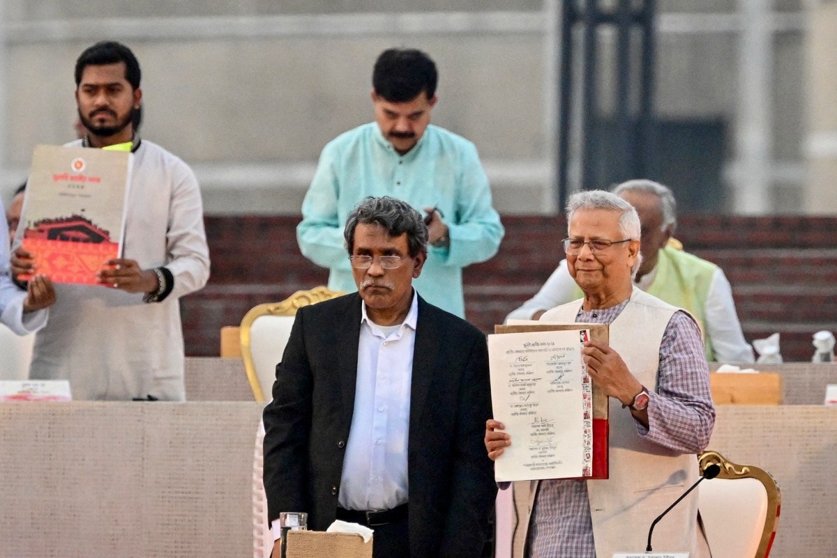 Muhammad Yunus and Head of the National Consensus Commission, shows the July National Charter on October 17, 2025