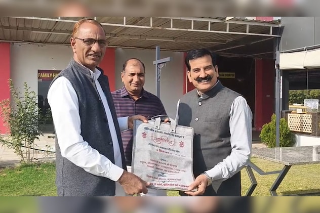 शादी का अनोखा निमंत्रण पत्र देखते हुए