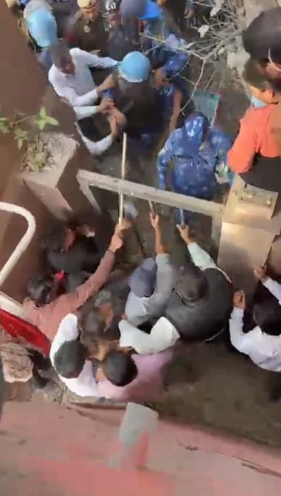 A student seen using a stick to hit a policeman