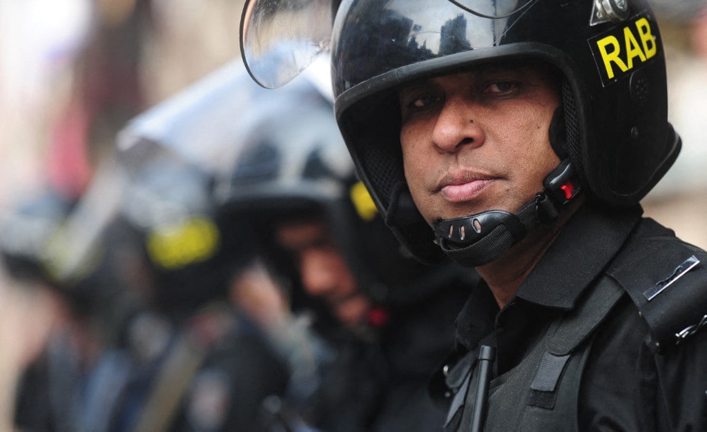 Bangladeshi elite force Rapid Action battalion (RAB) members stand guard in front of the Bangladesh Nationalist Party office in 2013