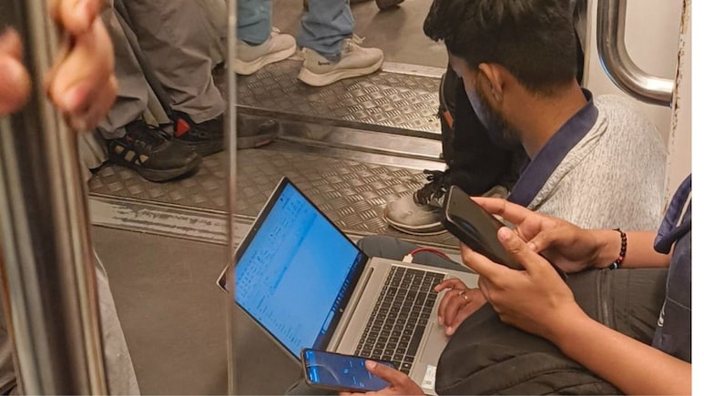 नौकरी का बोझ! बॉस का फोन आते ही मेट्रो के फर्श पर बैठकर काम करने लगा शख्स, छिड़ गई बहस