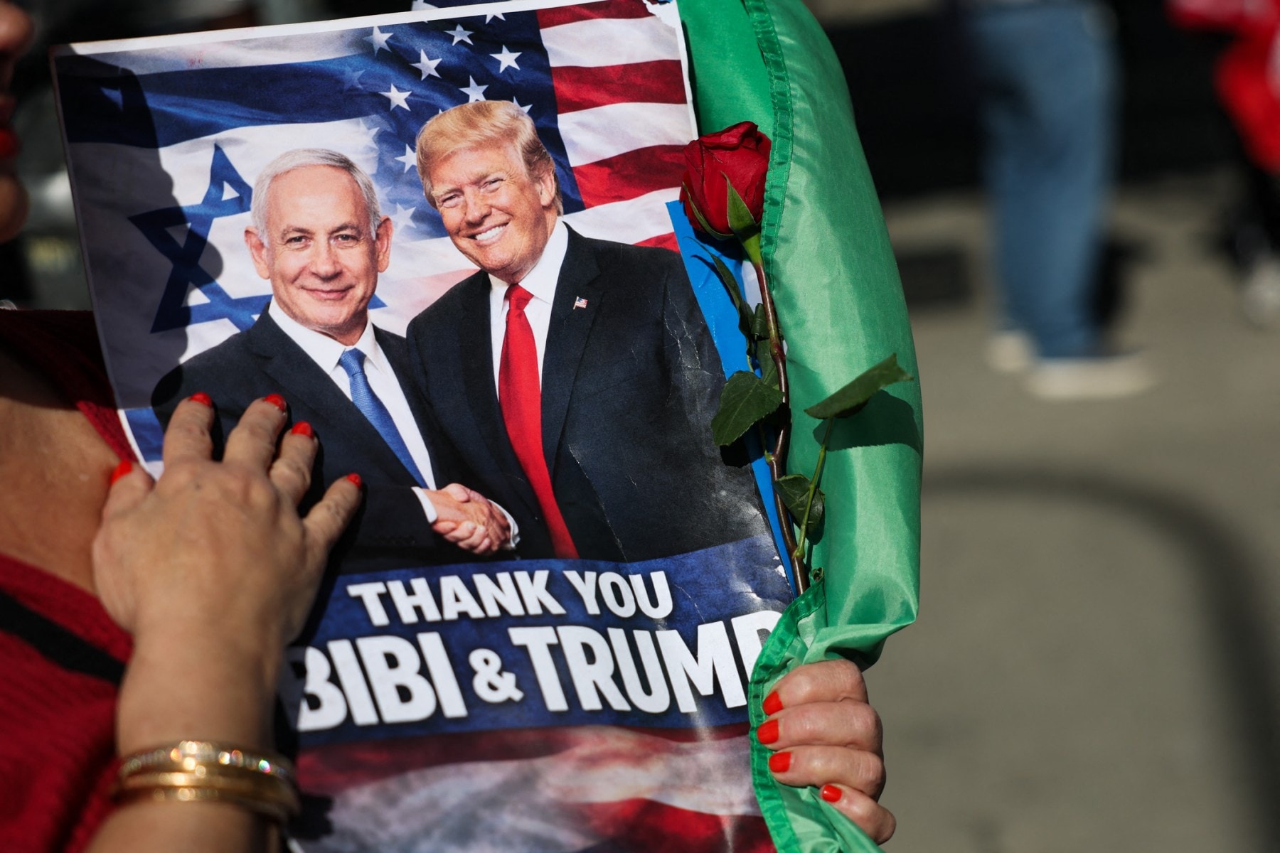 A person holds a sign supporting Israeli Prime Minister Benjamin Netanyahu and US President Donald Trump during a gathering of Iranian community members showing support for Israel and the United States, outside the Consulate General of Israel in Los Angeles, on March 5, 2026.