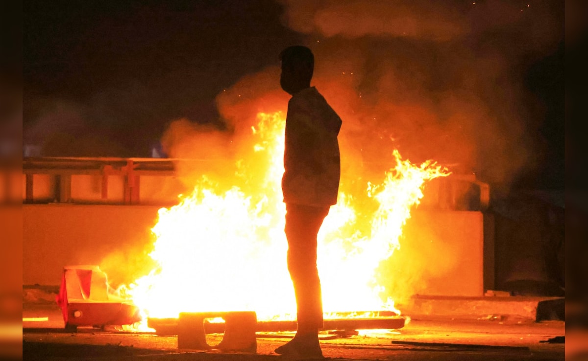 A protester stands near fire while approaching US embassy in Baghdad