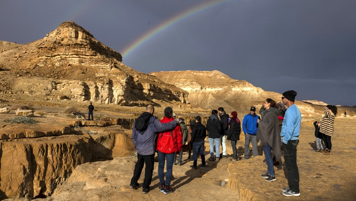 A rainbow forms as Israelis wait for a flash-flood to take place in the Negev desert.