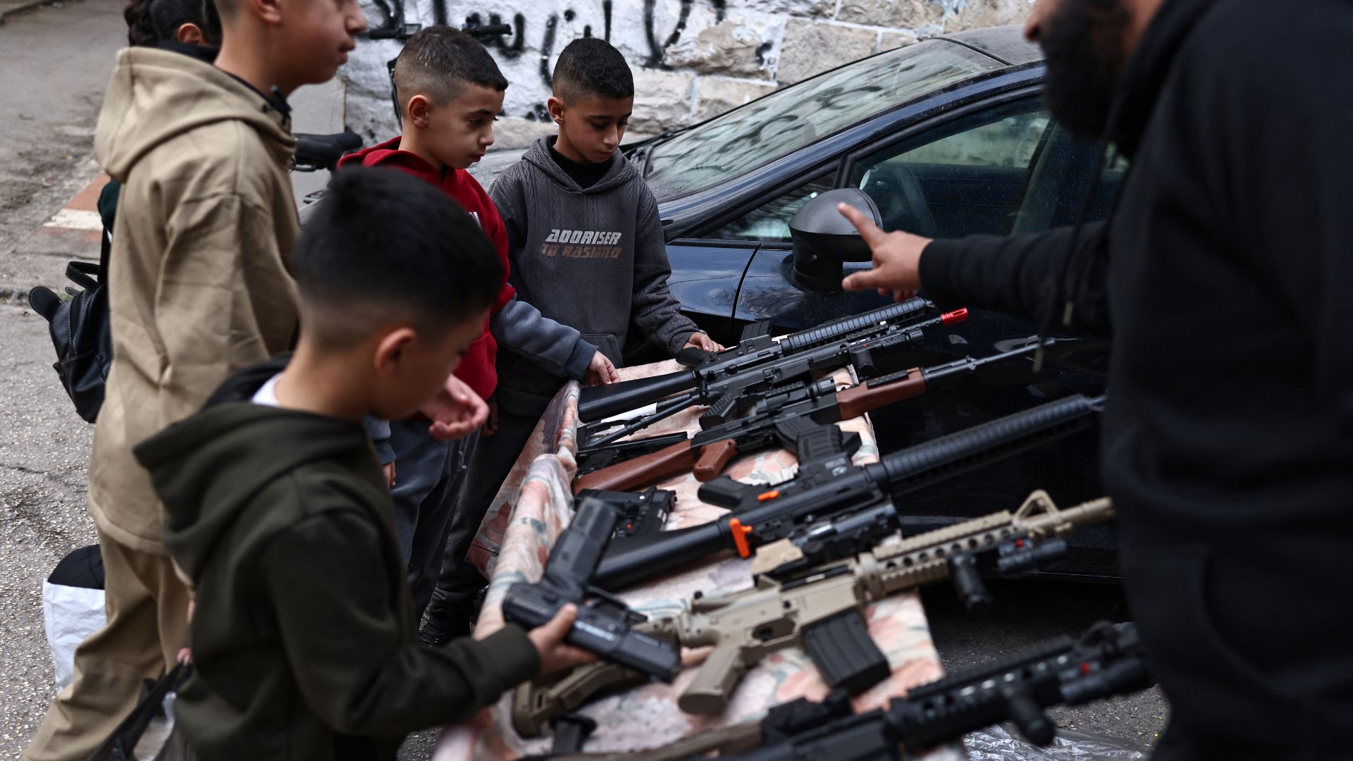 वेस्ट बैंक में बच्चे ईद से पहले खिलौने वाले बंदूक खरीदते हुए (AFP)
