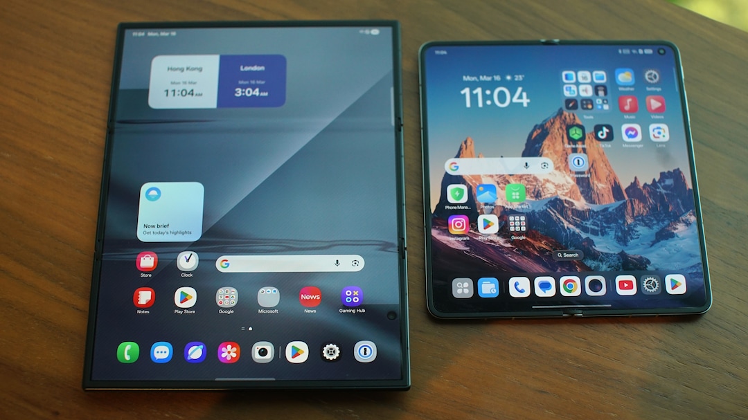 The Oppo Find N6, right, next to the Samsung Galaxy Z TriFold. The Trifold's crease lines are tangible and visible as distortions in the screen; the Find N6 is the first device in this class to not suffer from the issue.