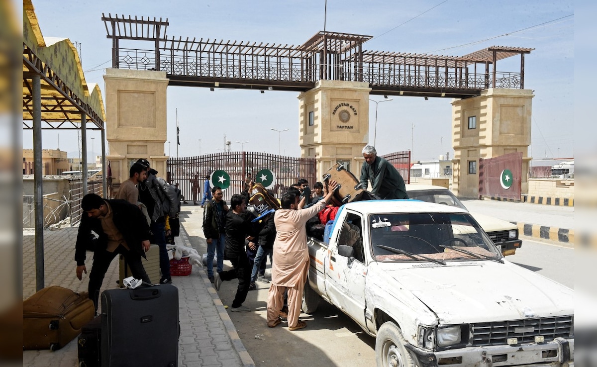 Pakistani nationals load their belongings onto a vehicle at the Pakistan-Iran border in Taftan. (AFP)