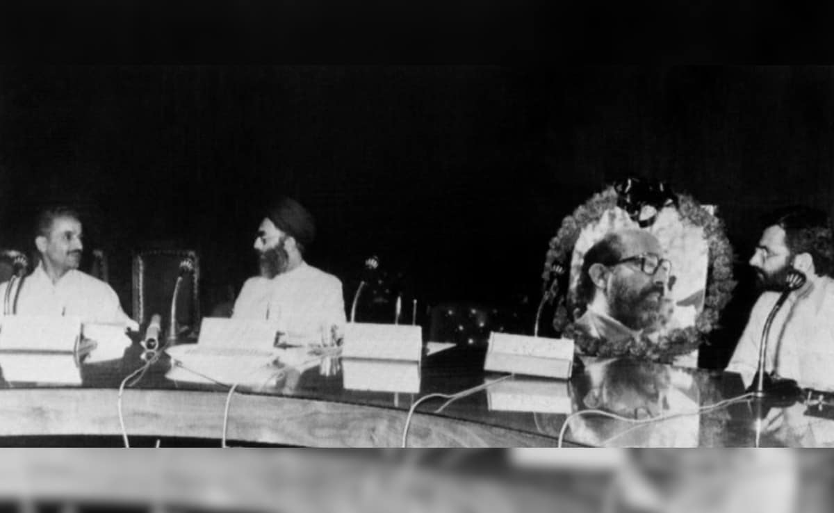 इस्लामी गणतंत्र ईरान के प्रधानमंत्री मोहम्मद-अली रजाई (बाएं) 27 जून, 1981 को सुप्रीम डिफेंस काउंसिल की एक बैठक के दौरान अली खामेनेई (बाएं से दूसरे) से बात कर रहे हैं. खामेनेई इसी दिन दोपहर में तेहरान की अबुजर मस्जिद में एक जानलेवा हमले का शिकार हुए थे. इस बैठक में, ईरान-इराक युद्ध के दौरान युद्धक्षेत्र में शहीद हुए डॉ. चमरान की तस्वीर उनकी खाली कुर्सी पर रखी हुई है.