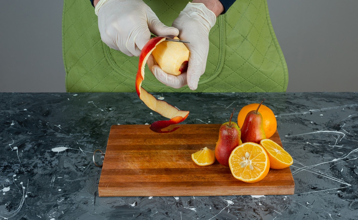 A person peeling the fruit to reduce chances of pesticide exposure