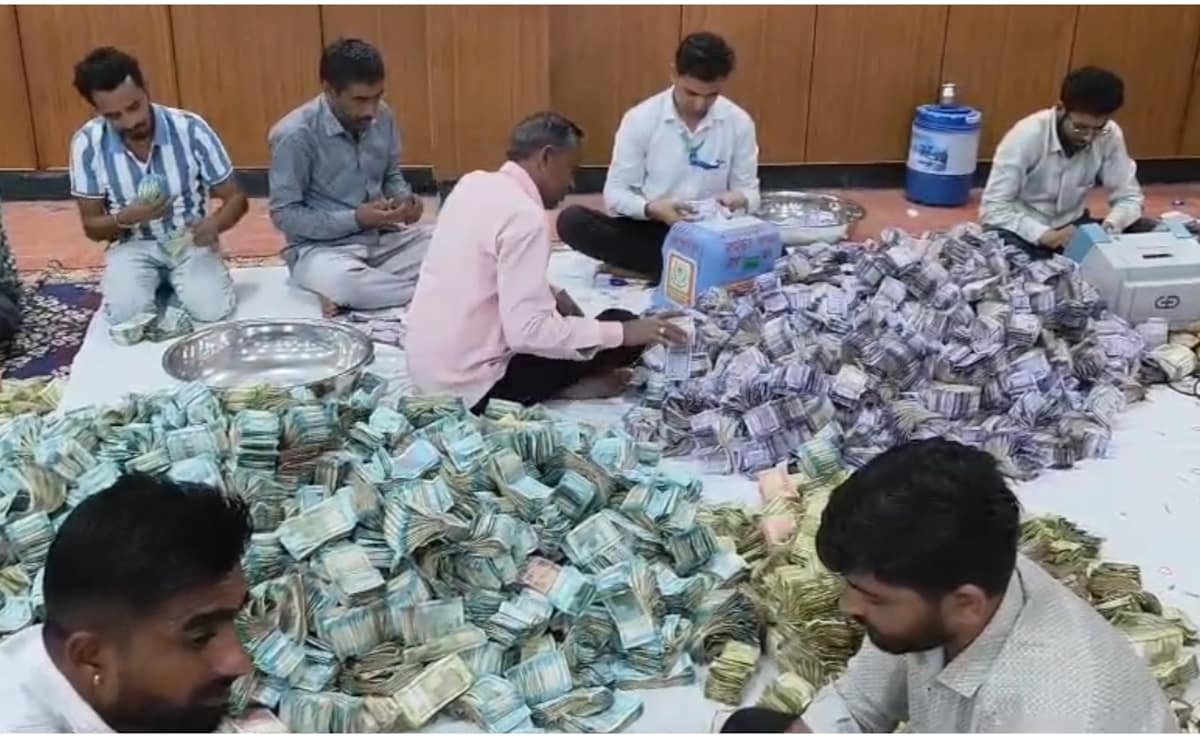 सीसीटीवी कैमरों की निगरानी में दानपात्र से निकले नोटों की गिनती करते हुए लोग.