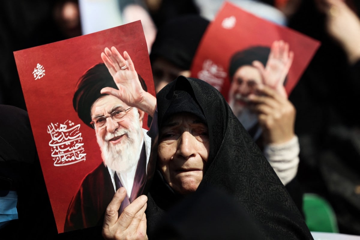 Women hold posters of slain leader Ayatollah Ali Khamenei during Friday noon prayers at the compound of the Mosalla mosque in Tehran on March 6, 2026