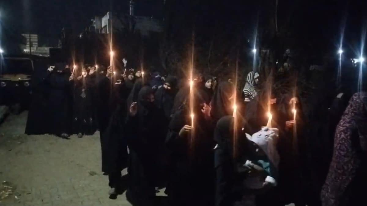 हाथों में मोमबत्तियां लेकर मार्च करतीं शिया महिलाएं